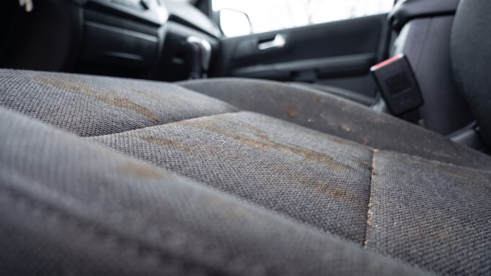 Asiento de tela con manchas, comparativa antes y después de la limpieza profunda (antes)